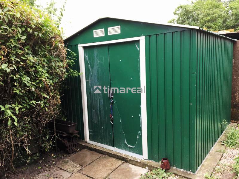 A garden at a family house in Bohdanovce nad Trnavou with a green metal garden shed.
