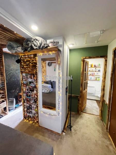 Interior of a family house with illuminated decorations, a mirror, and photos on the wall.