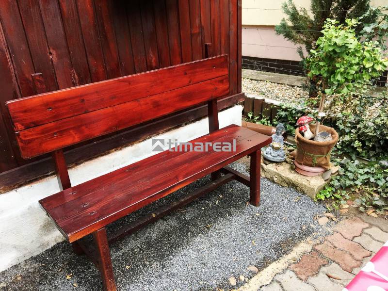 A wooden bench with a plant and decorative ornament at a family house in Bohdanovce nad Trnavou.