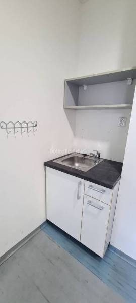 Offices with a cabinet, sink, and shelf, floor with wood decor.