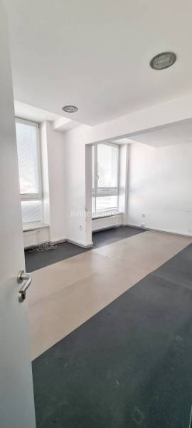 Offices with large windows and gray flooring in a neutral color.