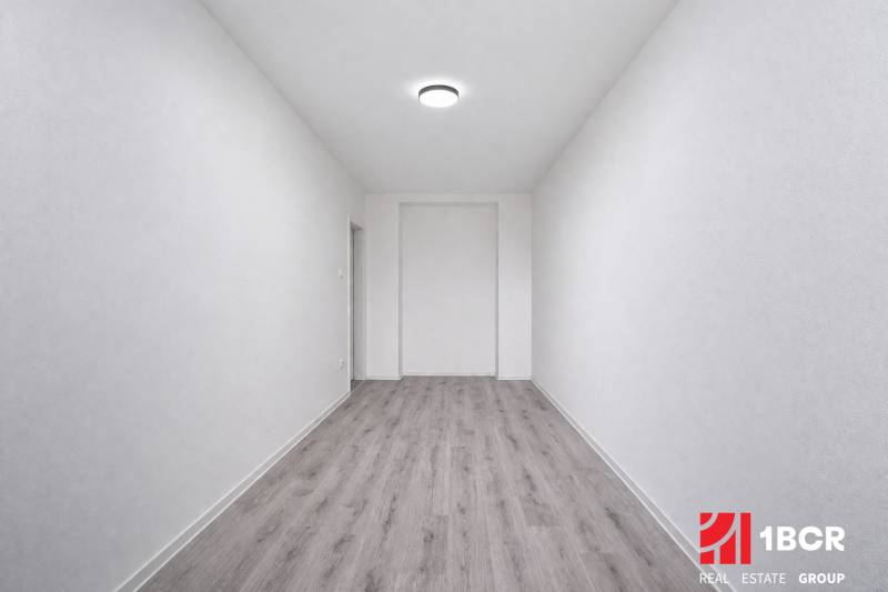 A narrow space with a wooden decor floor in a 3-room apartment.