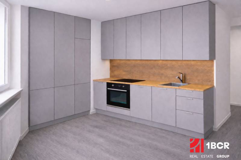 A kitchen with gray cabinets, wooden floor decor, and lighting for a three-room apartment.