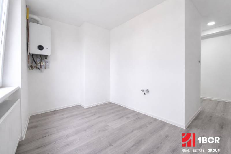 A room with a boiler and a wooden decor floor in a 3-room apartment.