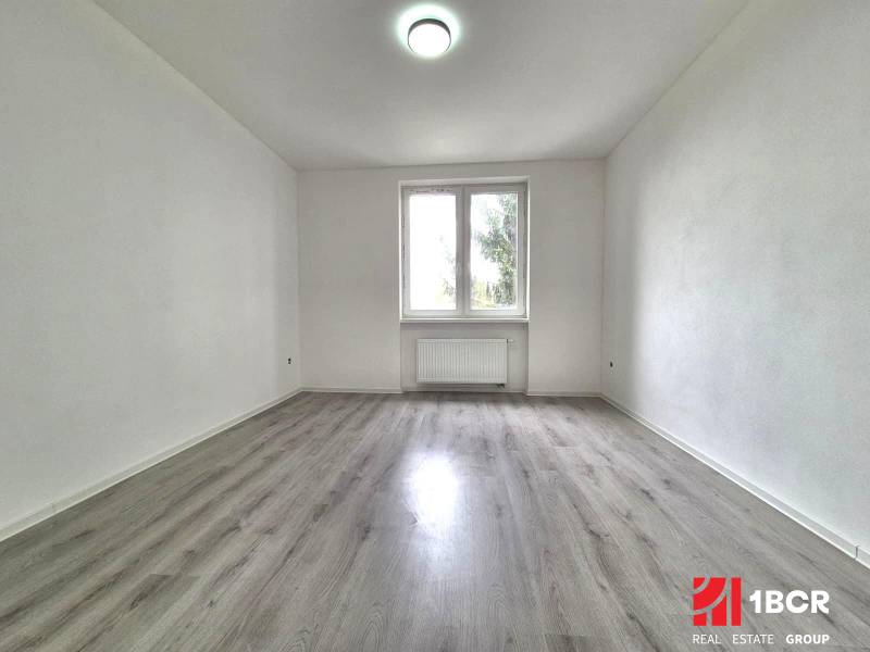 An empty room with wooden floor decor and white walls in a 3-room apartment.