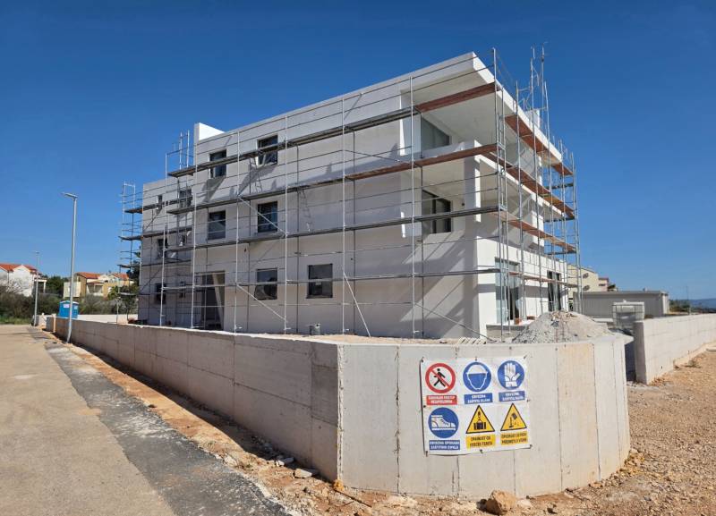 A building with scaffolding in SRIME, a 3-room apartment under construction.
