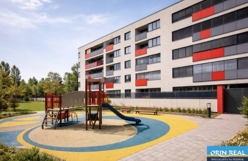 Malokrasňanská Street in Bratislava - Rača with an apartment building and a children's playground.