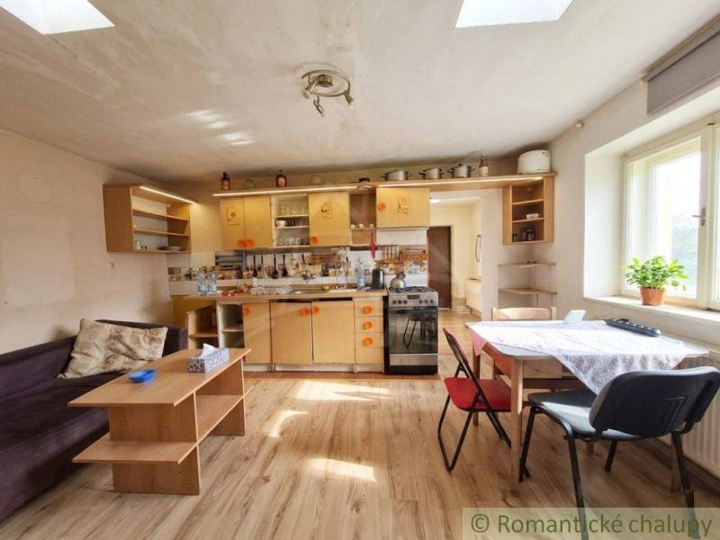 A kitchen in a family house with a wooden decor floor, bright interior, and simple furniture.