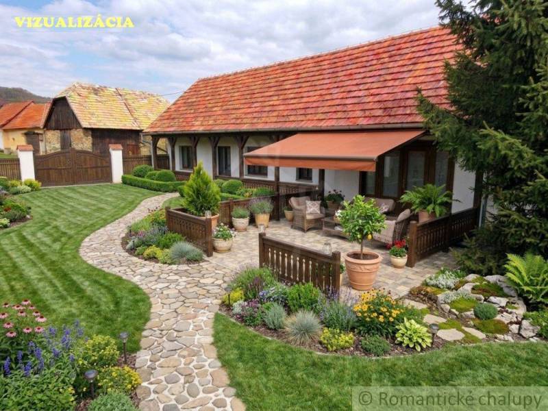 A family house in Ozdín with a flower garden and a paved terrace under an awning.