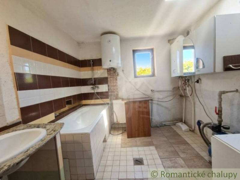 Bathroom with a tiled floor and a bathtub in a family house.