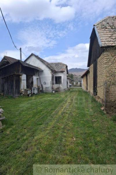 A family house in Ozdín surrounded by a grassy plot and farm buildings.