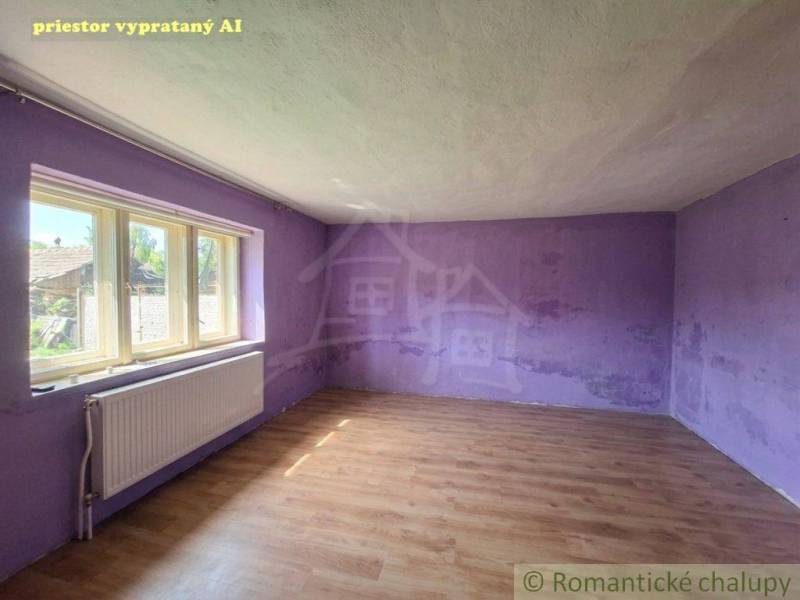 An empty room with purple walls in a family house, wooden decor flooring.