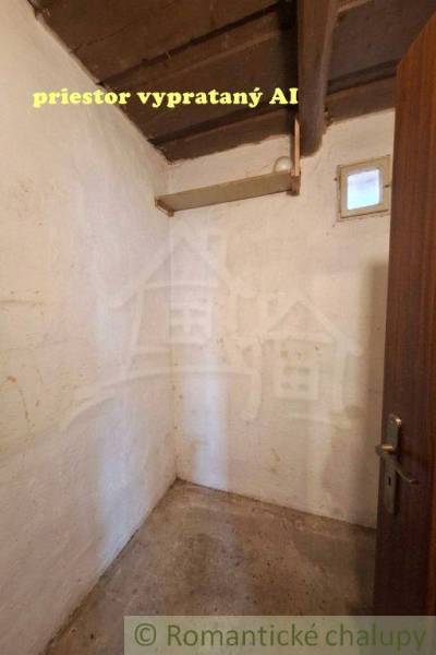 A small room with a concrete floor in a family house, wooden ceiling, simple walls.