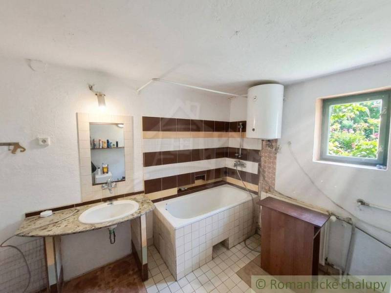 A bathroom in a family house with a sink, a bathtub, and a boiler.
