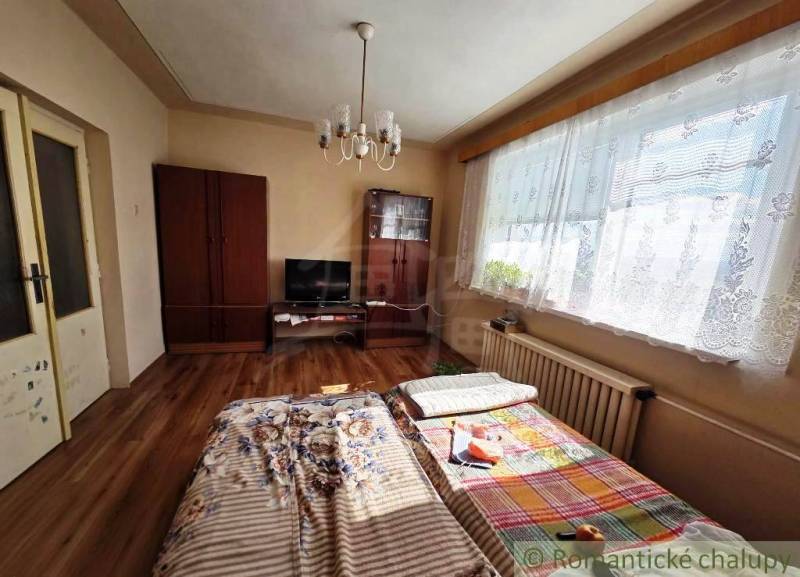 A room in a family house with a bed, a wardrobe, and a floor with a wooden decor.