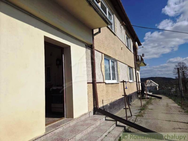 A family house in Kiarov with a staircase and large windows, on a rural street.