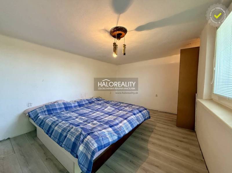 A peaceful bedroom with a simple bed and a wooden decor floor.
