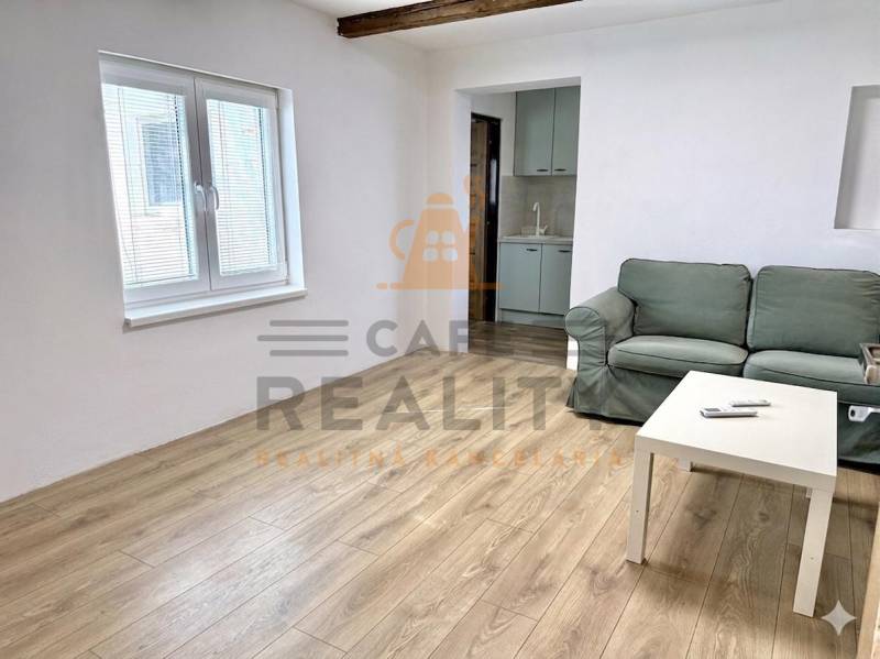 Living room in a family house with a sofa, table, and floor with wooden decor.