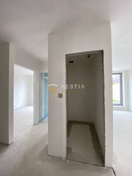 Interior of an unfinished 2-room apartment with plastered walls and a large window.