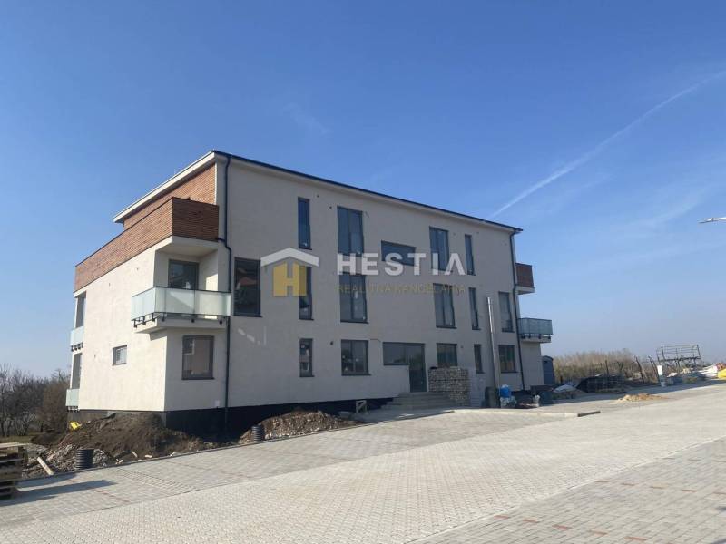 A three-story building with balconies in Petrová Ves on a paved area.