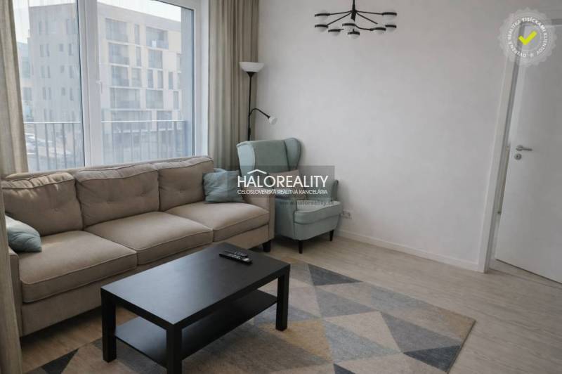 Living room with a sofa, armchair, and table, floor with wooden decor.
