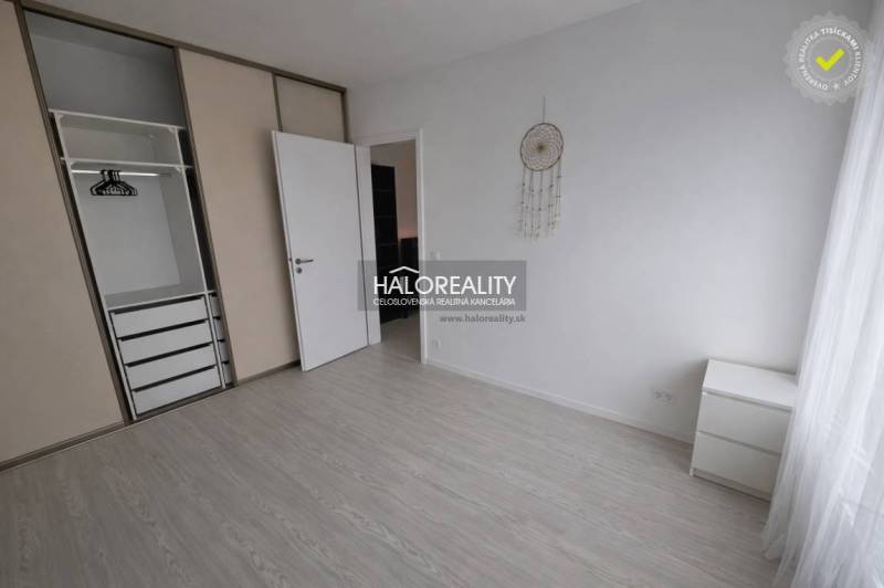 Interior of a 2-room apartment with a built-in wardrobe and flooring with a wood decor.