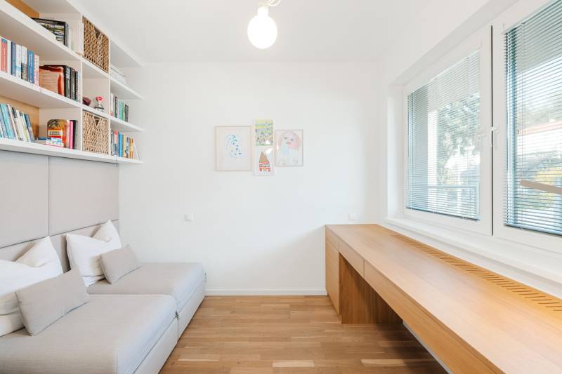 Bright room with wood-patterned flooring, a sofa, and large windows.