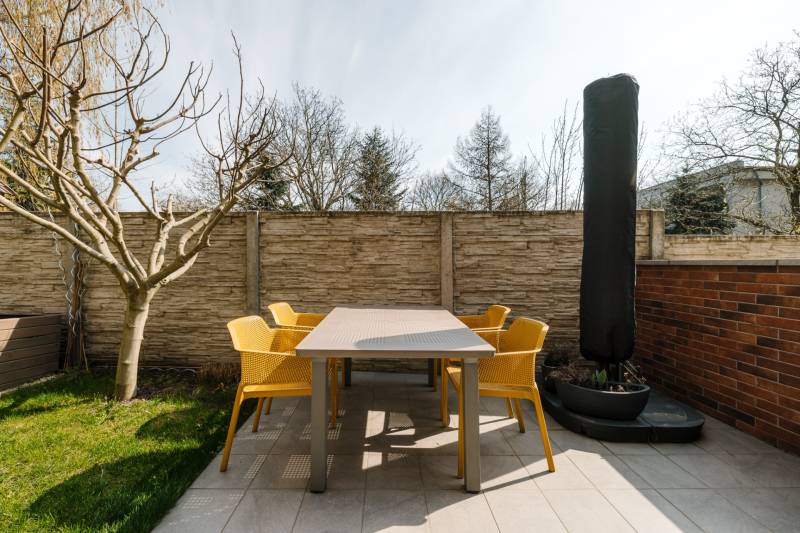 Terrace of a 4-room apartment on Cesta na Klanec in Lamač, with modern furniture and a tree.