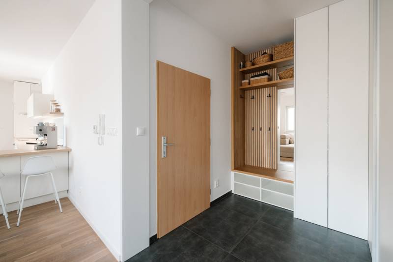 Entrance hallway with storage space, flooring with decor, and a kitchenette in a 4-room apartment.