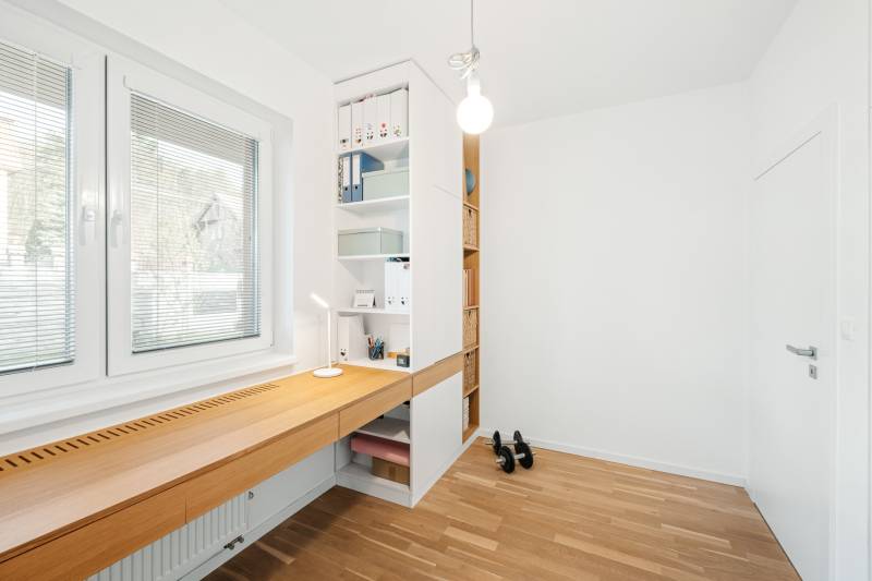 A study with a wooden desk and shelves in a 4-room apartment, floor with wooden decor.