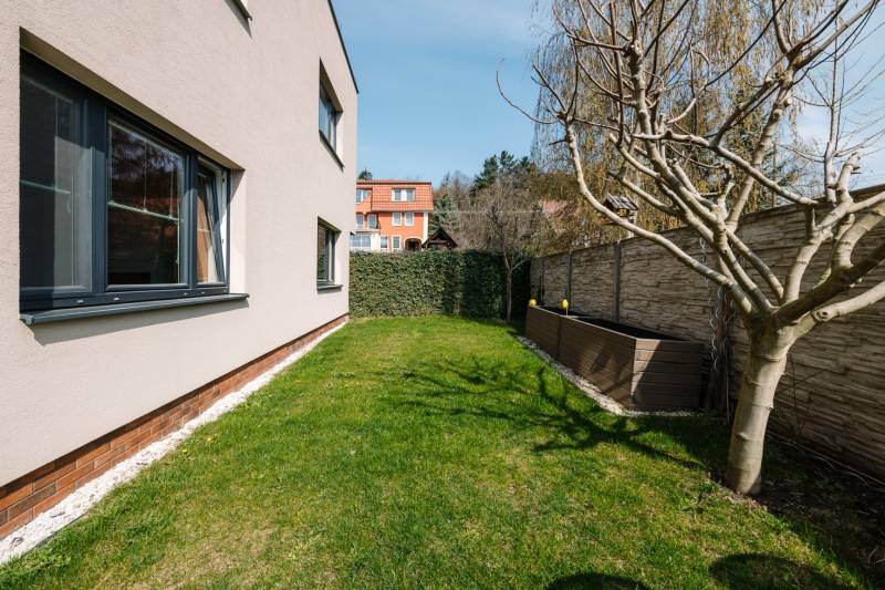 A garden with a lawn and a tree at a 4-room apartment on Cesta na Klanec in Lamač.