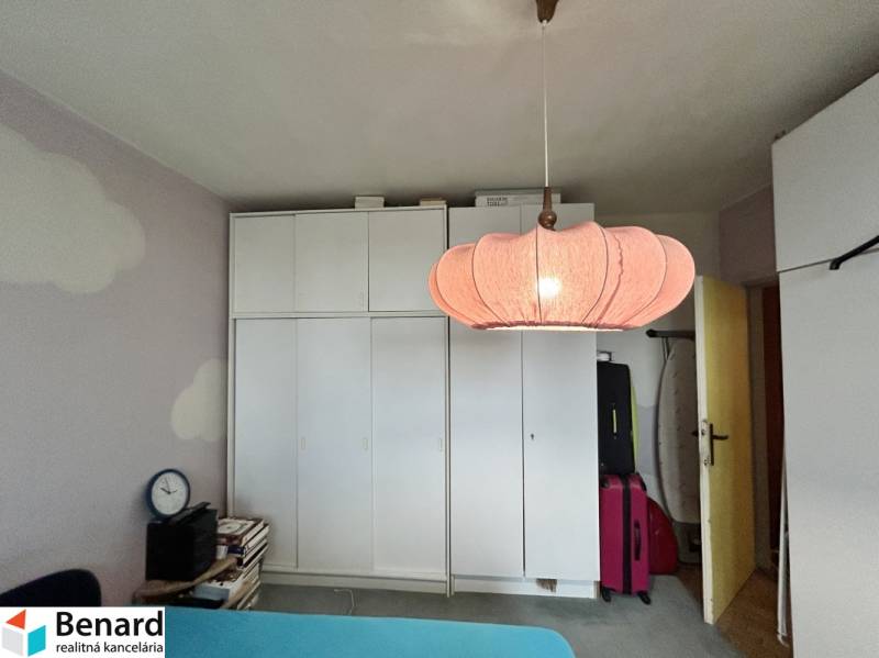 White built-in wardrobe with an interesting light fixture in a 3-room apartment.