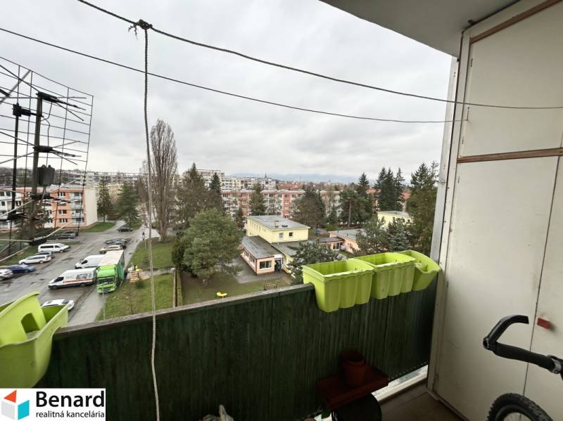 View from the balcony of a 3-room apartment on Októbrová Street in Prešov, parking lot and greenery.