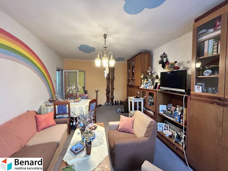 Living room in a 3-room apartment with sofas, furniture, and a painted rainbow on the wall.