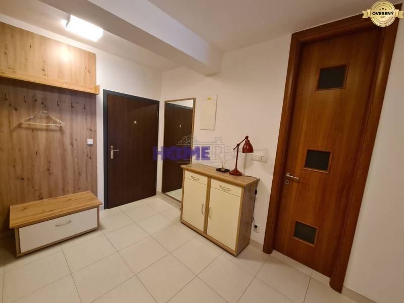 A hallway in a 2-room apartment with a shoe cabinet and a coat rack made of wood decor.