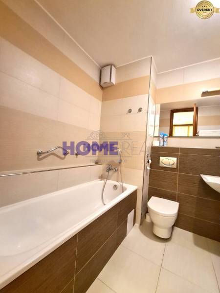 Bathroom with a bathtub, urinal, and sink in a 2-room apartment.