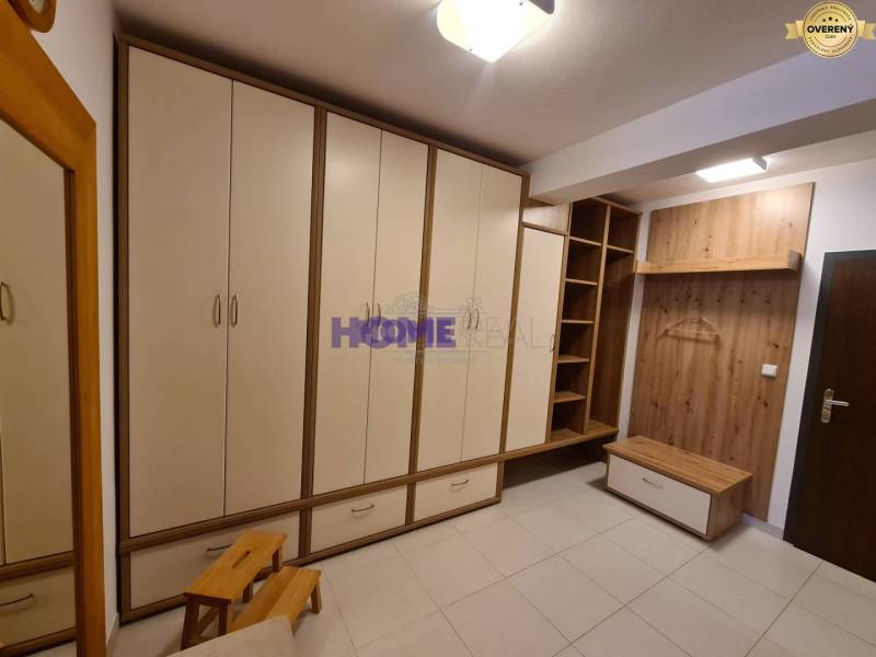 A hallway in a 2-room apartment with spacious closets and a coat rack wall.
