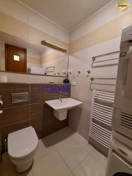 Bathroom in a 2-room apartment with a toilet, sink, and a white ladder radiator system.