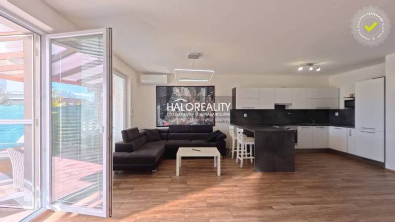 Living room and kitchen in a two-room apartment with a wooden decor floor.