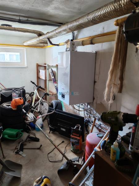 The shed in the family house contains a bicycle, tools, a boiler, and various sports equipment.