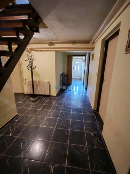 An interior with black wall tiles and a staircase in a family house.