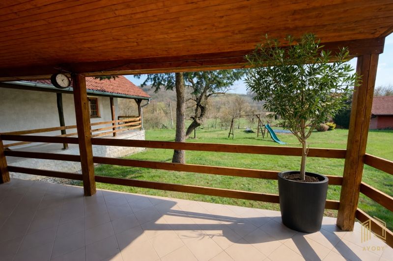 Terrace in a family house in Podbranč, overlooking a garden with a swing and a slide.