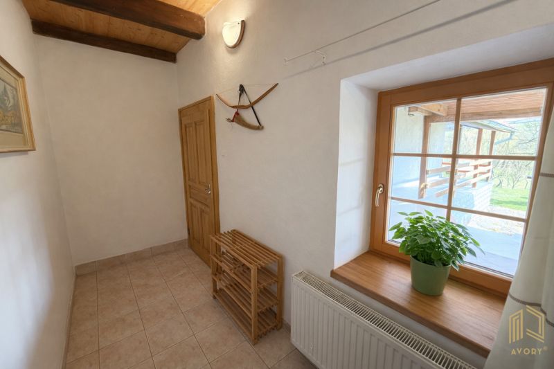 A cozy hallway in a family house with wooden elements and a plant on the windowsill.