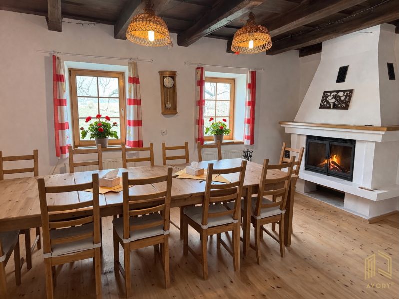 Dining room in a family house with a fireplace, wooden table, and decorative elements.