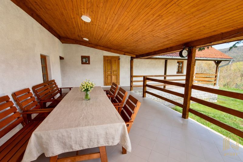 The terrace of a family house in Podbranč with a wooden ceiling and seating.