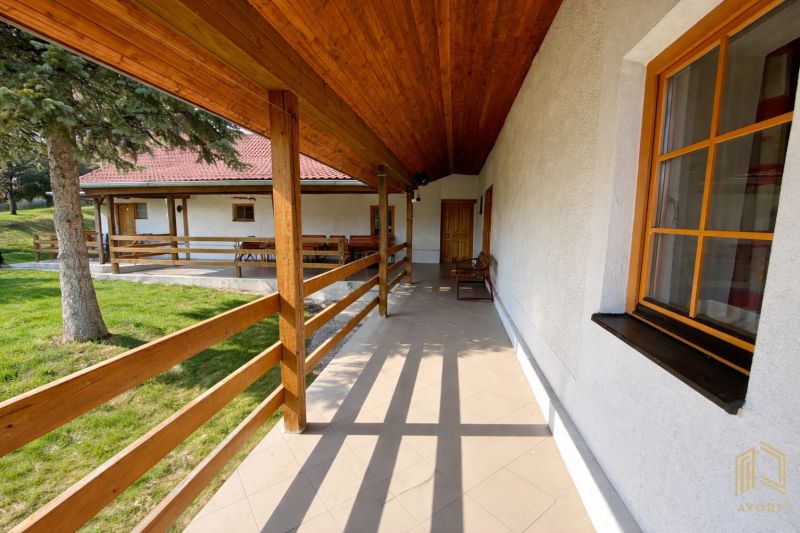 A terrace in a family house in Podbranč with wooden railings and a view of the yard.