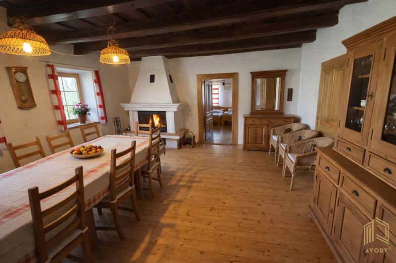 A dining room with a fireplace and wood-patterned flooring in a family house.