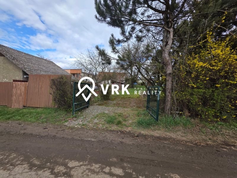 A gate surrounded by greenery and a fence on residential land in Bohdanovce.