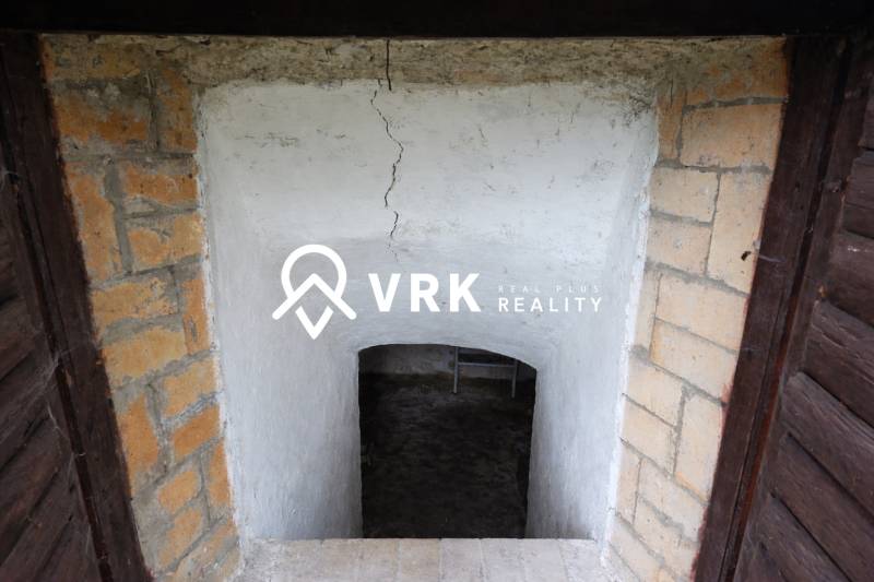 Entrance to a basement space with plastered walls and a brick frame, Land - residential.