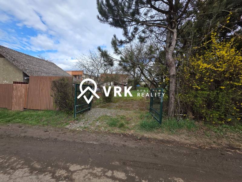 A gate surrounded by greenery and a fence on residential land in Bohdanovce.